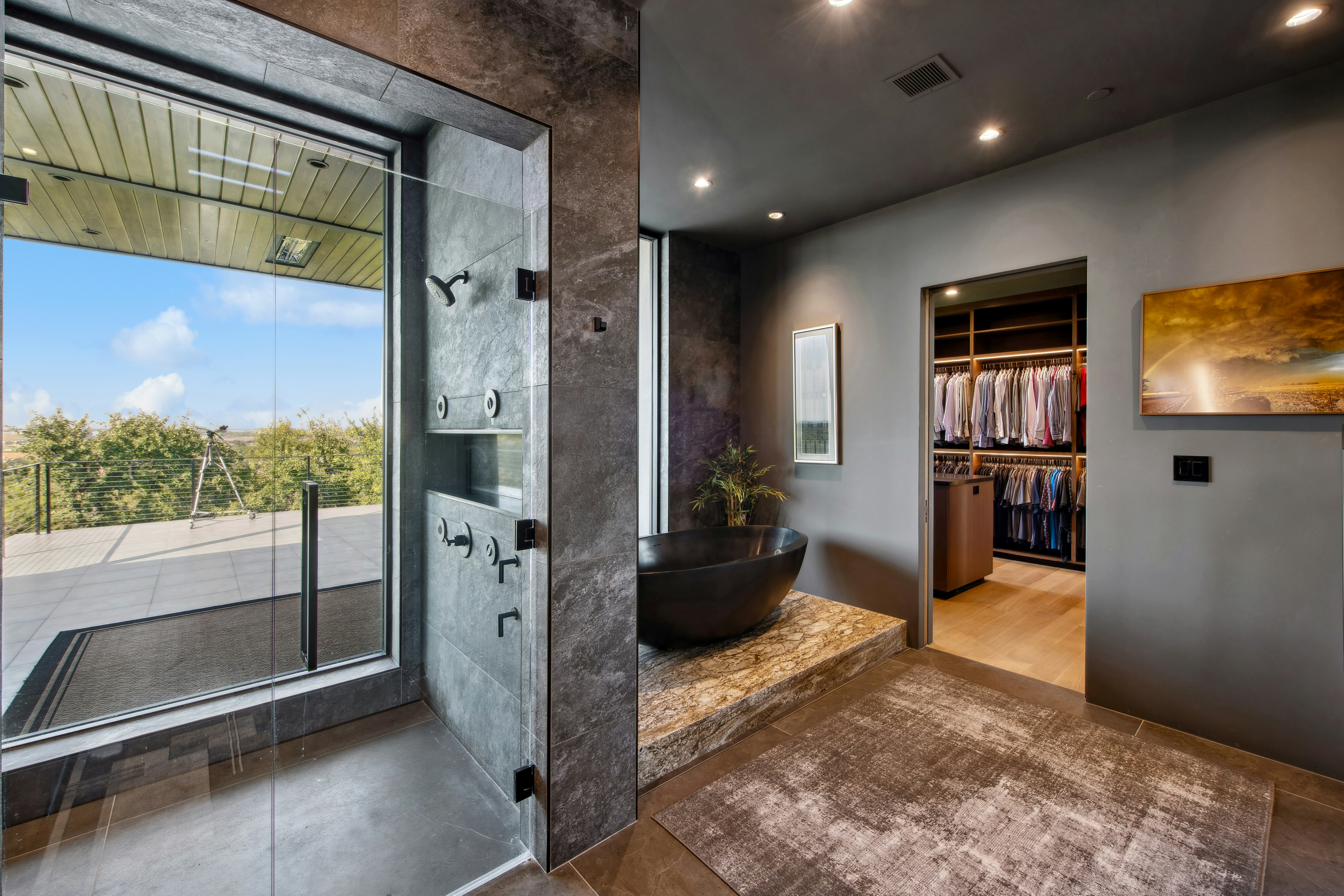 A modern luxury bathroom featuring a custom glass shower enclosure